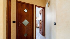 Una porta in legno con una finestra a forma di diamante e una maniglia.