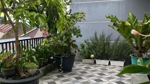 A balcony with potted plants and a checkered floor. - MOZA HOUSE Wonosobo (Wonosobo)