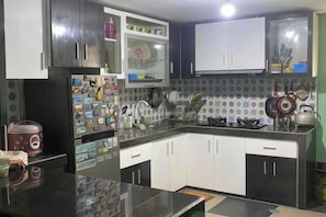 A kitchen with a refrigerator, stove, sink, and cabinets. - MOZA HOUSE Wonosobo (Wonosobo)