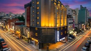 A modern hotel with a unique angular design, multiple floors, and a prominent entrance. - Urban HOTEL&PLAY (Seoul)