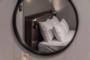 A bed with white bedding, a headboard, and two wall-mounted light fixtures. - Urban HOTEL&PLAY (Seoul)