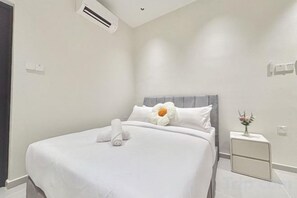 A hotel room with a bed, a bedside table, and a wall-mounted air conditioner. - HH Villa Private Pool Bercham (Ipoh)