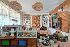 A shop interior with wooden shelves, a display counter, and hanging items. - Baan Yung Hill Resort (Chiang Rai)