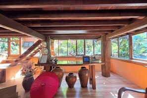A room with a wooden ceiling, a desk with a laptop, and large windows. - Baan Yung Hill Resort (Chiang Rai)