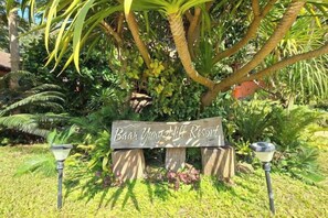 A wooden sign with the text 'Baan Yung Hill Resort' in a lush garden setting. - Baan Yung Hill Resort (Chiang Rai)