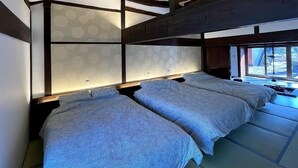 A bedroom with two beds, a wooden ceiling, and a window with a view. - KandoStay Yatsugatake Fujiyama Terrace (Hokuto)