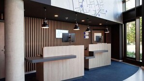 A reception area with two counters, a large map on the wall, and a view of the outdoors through large windows. - Holiday Inn Express & Suites MONHEIM AM RHEIN by IHG (Bedburg)