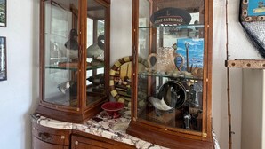 Een houten kast met glazen deuren, gevuld met diverse voorwerpen.