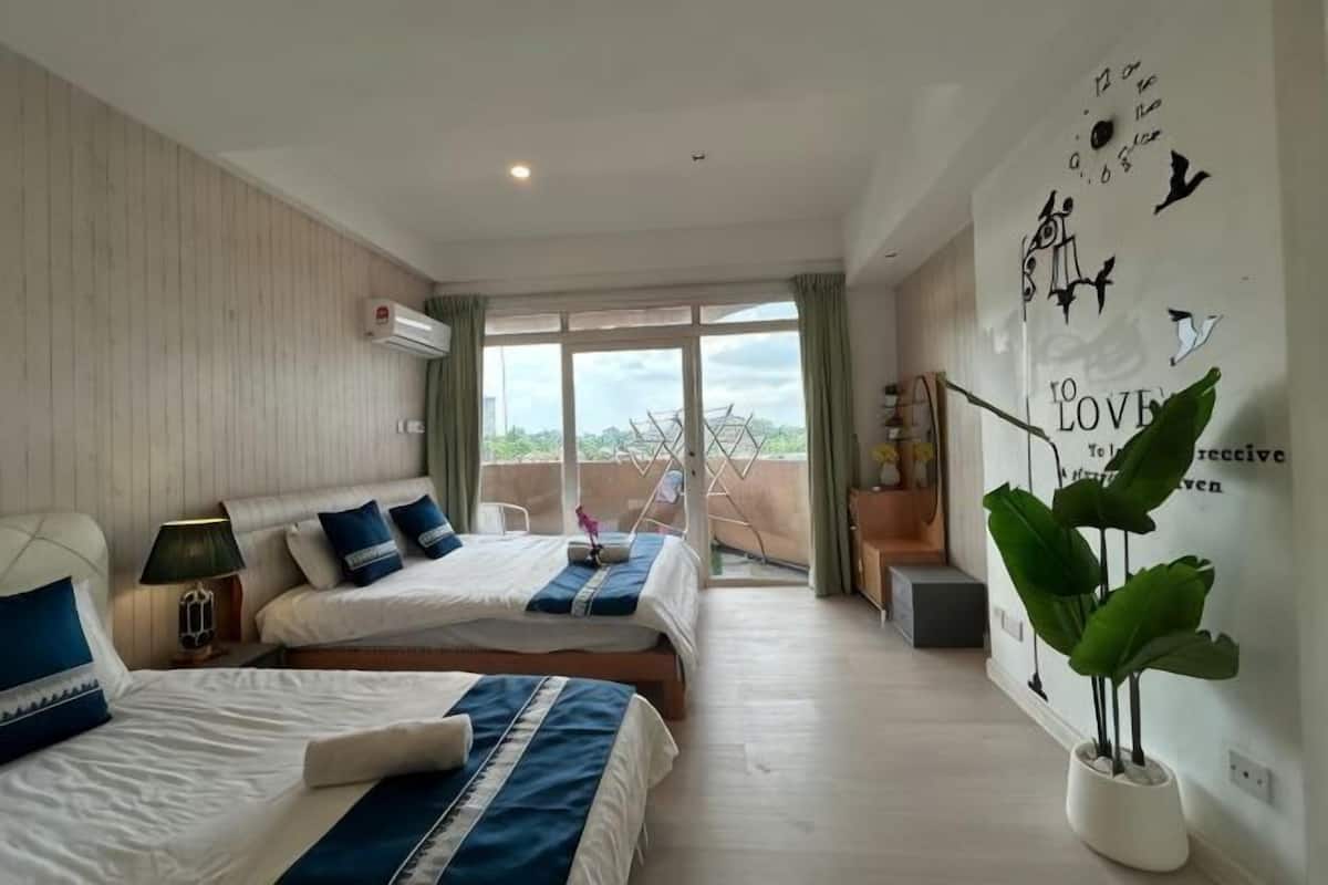 Een hotelkamer met twee bedden, een balkon en een muur met decoratieve details.