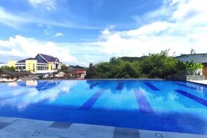 A swimming pool with clear blue water, surrounded by a tiled deck and a building in the background. - Ipoh Kinta Riverfront 5th Floor Fully Air-Con (Ipoh)