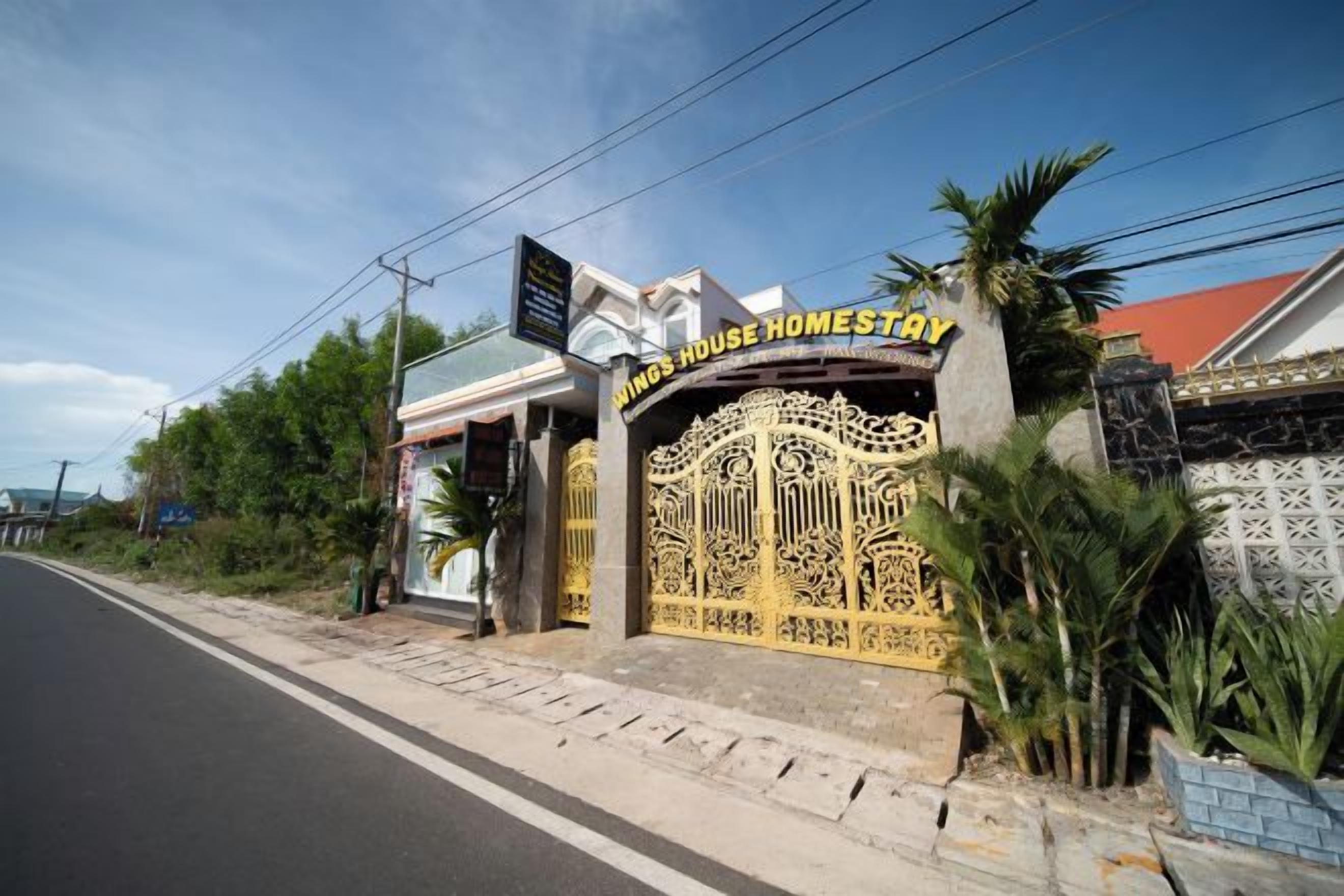 A gated entrance to a property named 'King's House Homestay' with a decorative gate and a signboard.