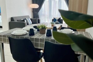 Ein Essbereich mit einem Tisch für vier Personen, einer Couch und einer Lampe.