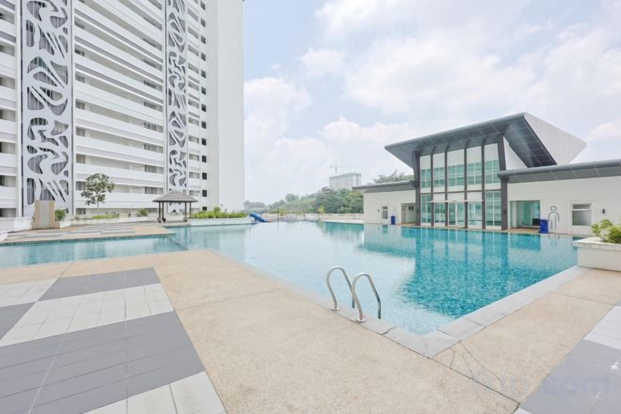 A swimming pool with a modern building and a tall structure in the background.