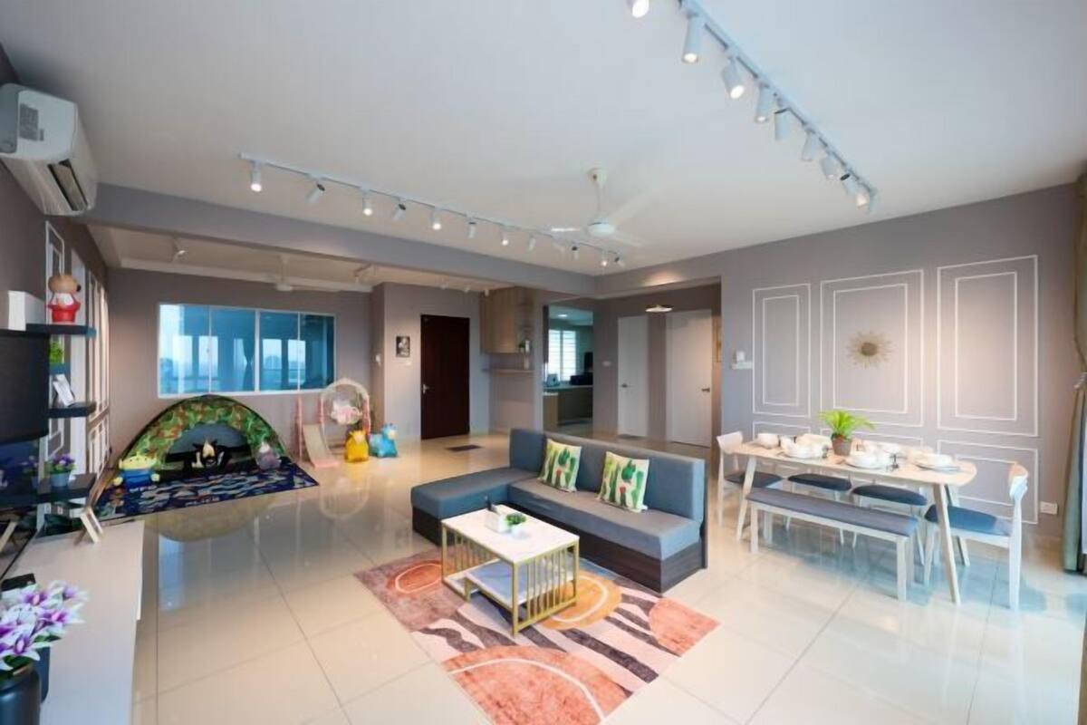 A spacious living area with a sofa, coffee table, and a dining table with chairs.