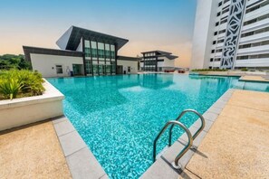 A swimming pool with a modern building in the background. - Vision Residence By Fei Hong (Puchong)