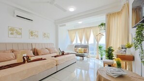 A modern living room with a sofa set, a dining table, and a view of the outdoors. - Vision Residence By Fei Hong (Puchong)