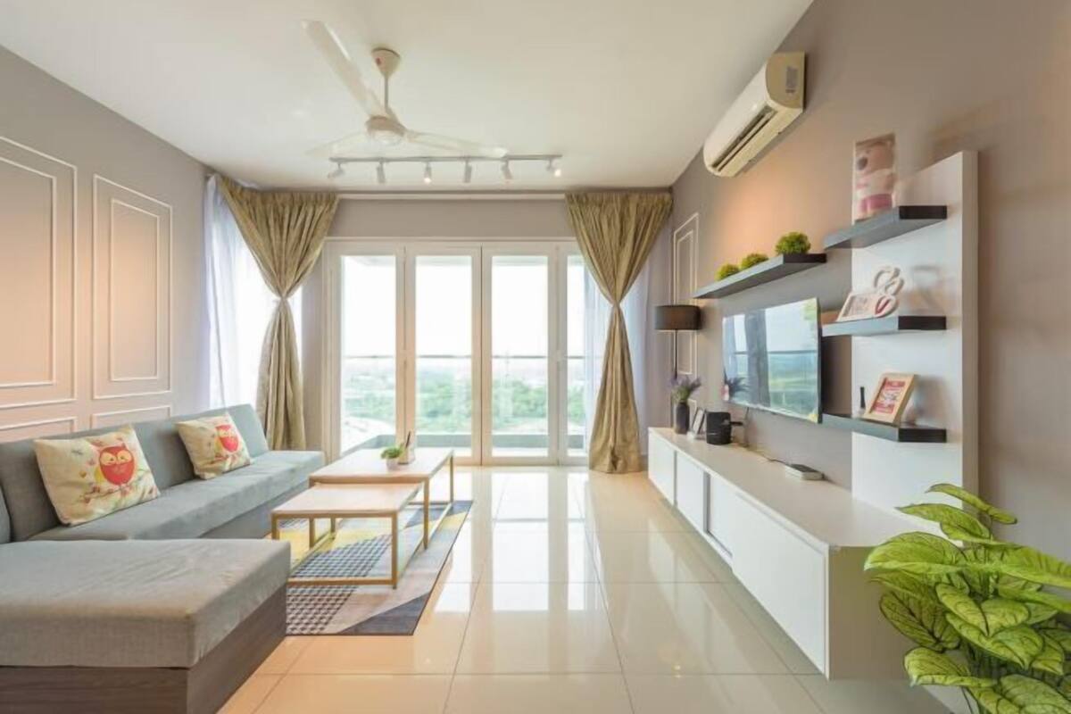 A modern living room with a sofa, TV, and shelves.