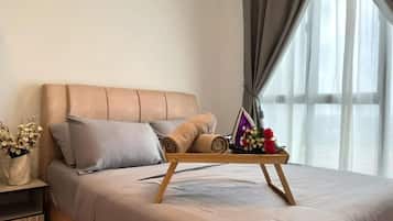 A neatly made bed with a wooden frame, a bedside table with a vase of flowers, and a window with sheer curtains.