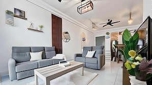 Una sala de estar moderna con dos sofás, una mesa de centro y objetos decorativos.