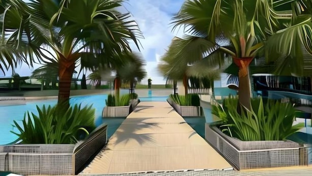 Un sendero conduce a una piscina rodeada de palmeras y macetas.
