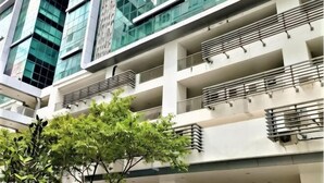 A multi-story building with balconies, large windows, and a tree in the foreground. - reStary Cartoon Themed Homestay (Kota Kinabalu)