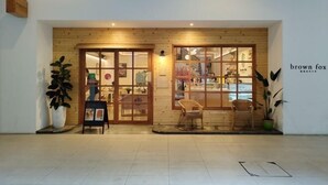 A storefront with a wooden facade, glass doors, and a sign reading "brown fox." - reStary Cartoon Themed Homestay (Kota Kinabalu)
