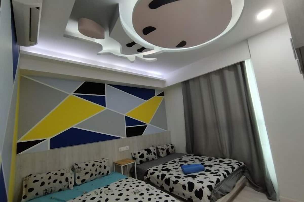 A hotel room with a modern design, featuring a geometric-patterned wall, a bed with a patterned bedspread, and a unique ceiling design.