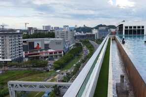 A long, narrow swimming pool with a view of a cityscape, including buildings and a road. - reStary Cartoon Themed Homestay (Kota Kinabalu)