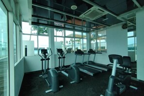 A gym with treadmills, elliptical machines, and stationary bikes. - reStary Cartoon Themed Homestay (Kota Kinabalu)