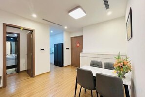 A hotel room with a dining area, a bed, and a bathroom.