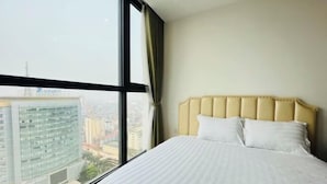 A hotel room with a large window, a bed with a headboard, and a view of the cityscape. - Vinhomes Skylake - Luxury apartment by Sunhouse Land (Hanoi)