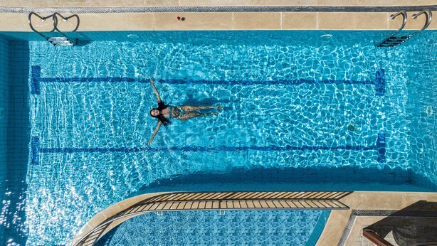A rectangular swimming pool with clear blue water, a diving board, and a tiled deck area. - Apartment '2 One Bedroom' with Sea View, Wi-Fi and Air Conditioning (Sfakaki)