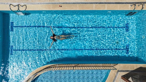 A rectangular swimming pool with clear blue water, a diving board, and a tiled deck area. - Apartment 'Groundfloor' with Sea View, Wi-Fi and Air Conditioning (Sfakaki)