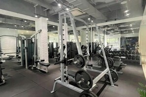A gym with weightlifting equipment, mirrors, and exercise machines.