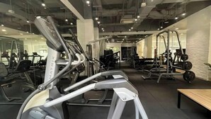 A gym with various exercise equipment, including treadmills and weight machines, and a bench. - The Wellington Homes - Botanica Premier Apartment - Nearby Airport Free Pool Gym (Ho Chi Minh City)