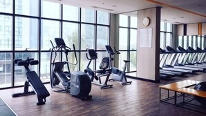 A gym with exercise equipment, large windows, and a wooden floor. - The Wellington Homes - Botanica Premier Apartment - Nearby Airport Free Pool Gym (Ho Chi Minh City)