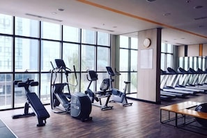 A gym with exercise equipment, large windows, and a wooden floor. - The Wellington Homes - Botanica Premier Apartment - Nearby Airport Free Pool Gym (Ho Chi Minh City)