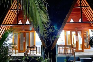 A two-story wooden structure with balconies, large windows, and a tropical plant in the foreground. - Wani Bali Resort 2 (Bali)