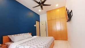 A bedroom with a bed, nightstand, wardrobe, ceiling fan, and a door. - leisurecorner 25 (Bukit Mertajam)