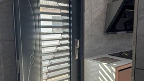 Une cuisine moderne dotée d’une cuisinière intégrée, d’un plan de travail blanc et d’une hotte noire.