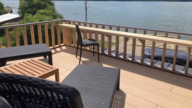 A wooden deck with outdoor furniture overlooking a lake and mountains. - [Panoramic view of the sea!] 28 minutes by car to Kinosaki Onsen (Kyotango)
