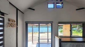 A room with a large sliding glass door leading to a beach, a small window with a view, and a wooden bench. - [Panoramic view of the sea!] 28 minutes by car to Kinosaki Onsen (Kyotango)