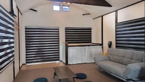 A modern room with a sofa, a small table, and two windows with blinds. - [Panoramic view of the sea!] 28 minutes by car to Kinosaki Onsen (Kyotango)