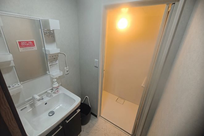 A bathroom with a sink, mirror, and shower door.