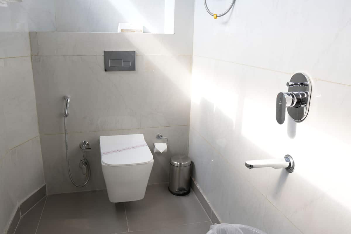 A small, modern bathroom with a toilet, bidet, and shower.