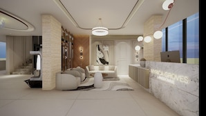 A modern reception area with a marble counter, a sofa set, and a staircase. - Myrica Groves Lansdowne (Lansdowne)