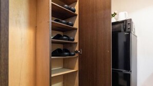 A wooden cabinet with shelves, a black refrigerator, and a white mug on top. - RS Namba, Dotonbori, Shinsaibashi Amemera (Osaka)