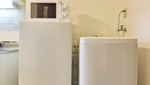 A kitchen with a white refrigerator, a built-in microwave, and a sink with a faucet. - RS Namba, Dotonbori, Shinsaibashi Amemera (Osaka)