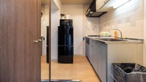 A compact kitchen with a refrigerator, sink, and cabinets. - RS Namba, Dotonbori, Shinsaibashi Amemera (Osaka)