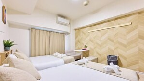 A hotel room with two beds, a small table, a chair, a potted plant, and an air conditioning unit. - RS Namba, Dotonbori, Shinsaibashi Amemera (Osaka)